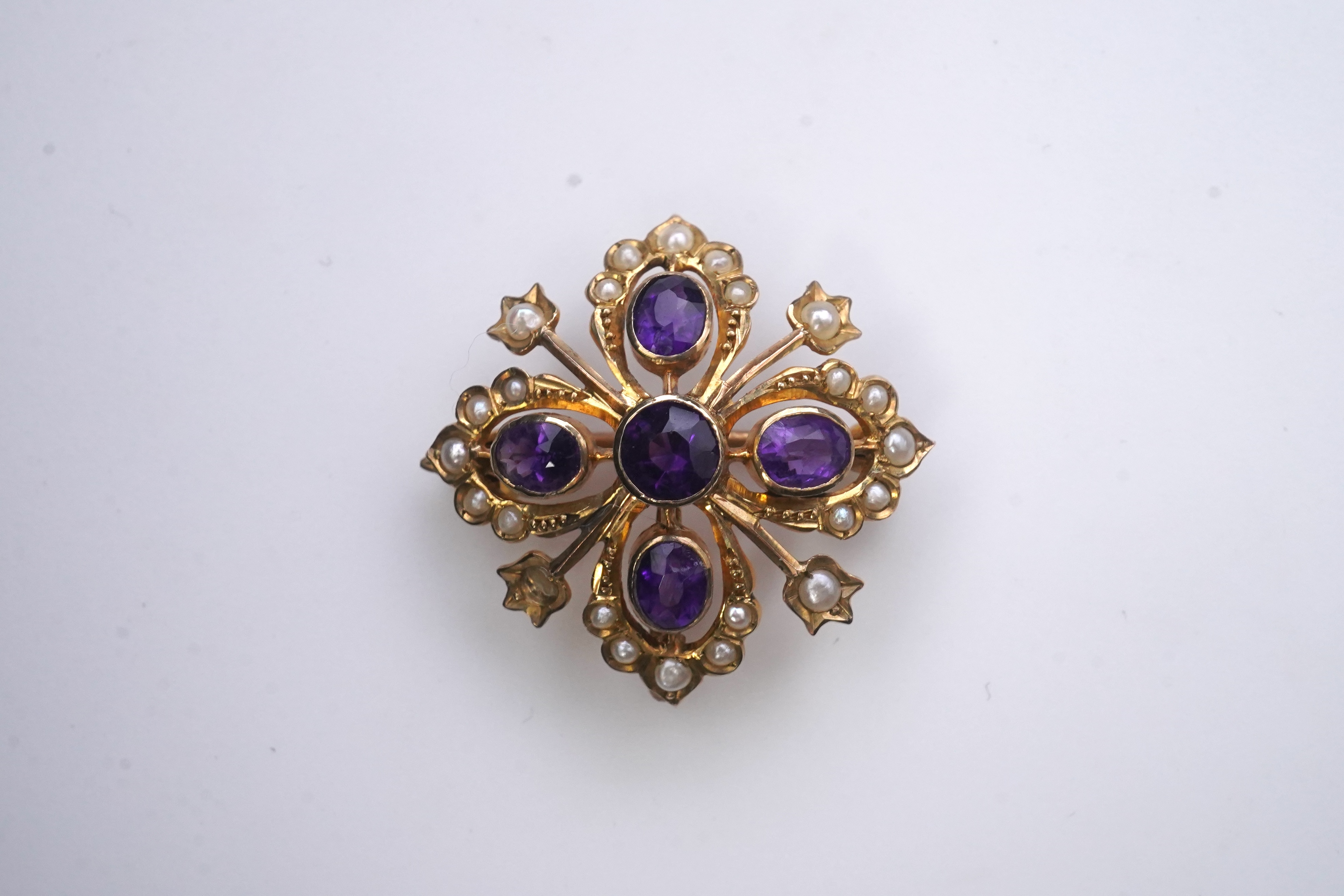 A Georgian mourning brooch, early 19th century, two Edwardian pendants, early 20th century